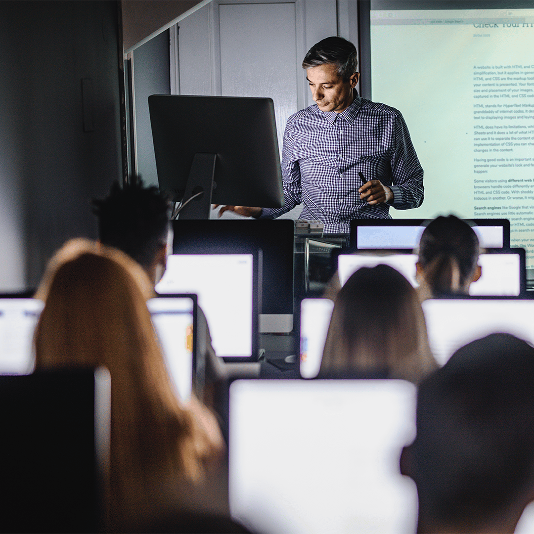 Teacher teaching a coding education class in a computer lab