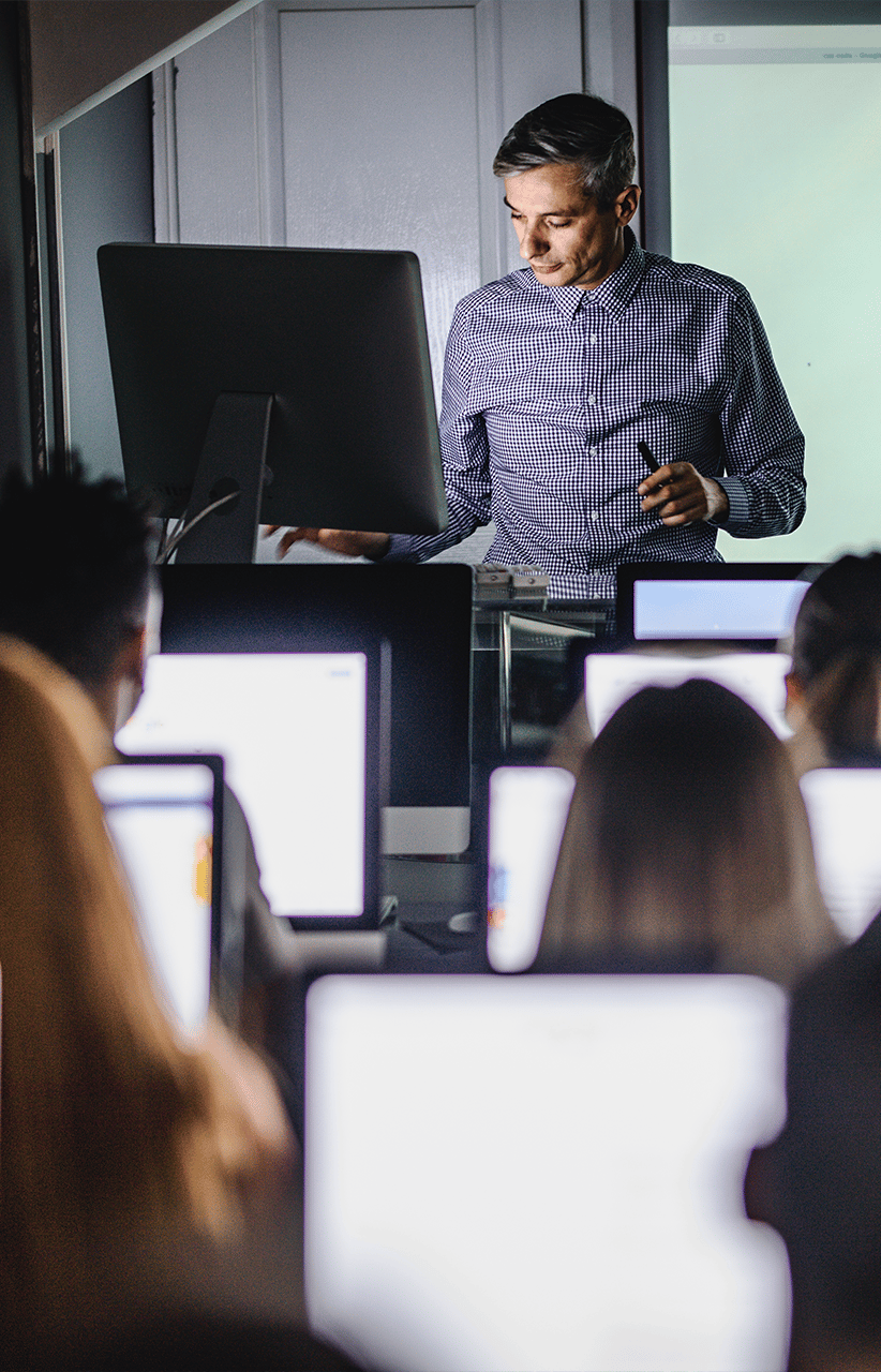 Teacher teaching a coding education class in a computer lab